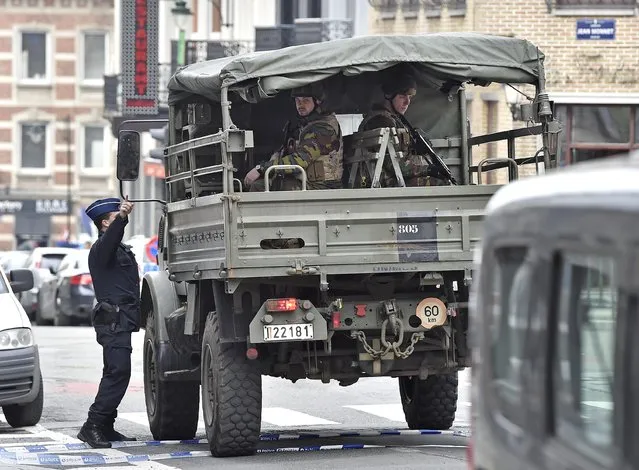 Police and military secure the city center in Brussels, Belgium, Tuesday, March 22, 2016. Authorities locked down the Belgian capital on Tuesday after explosions rocked the Brussels airport and subway system, killing a number of people and injuring many more. Belgium raised its terror alert to its highest level, diverting arriving planes and trains and ordering people to stay where they were. Airports across Europe tightened security. (Photo by Martin Meissner/AP Photo)