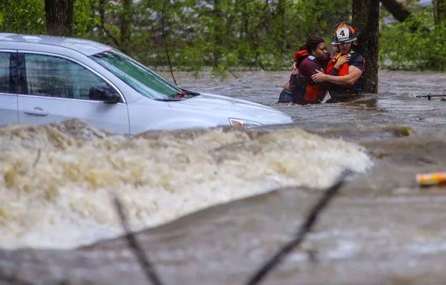 Little Rock Fire Capt. Steve Kotch, right, uses a cable safety line to rescue an unidentified woman from her flooded car in Boyle Park in Little Rock, Ark., during heavy rainfall Wednesday, March 30, 2016. Lightning and heavy rains hit central Arkansas during the evening rush hour. (Photo by Stephen B. Thornton/The Arkansas Democrat-Gazette via AP Photo)