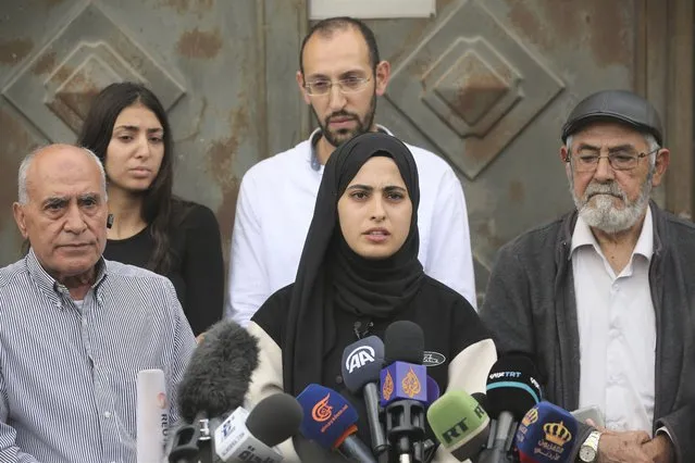Palestinian activist Muna al-Kurd, center, speaks at a press conference in the Sheikh Jarrah neighborhood of east Jerusalem, with her father, right, and neighbors, November 2, 2021. Palestinian families in the tense neighborhood of Jerusalem have rejected an offer that would have delayed their eviction by Jewish settlers. In a statement on Tuesday, the four families said their decision springs from “our belief in the justice of our cause and our right to our homes and our homeland”. (Photo by Mahmoud Illean/AP Photo)