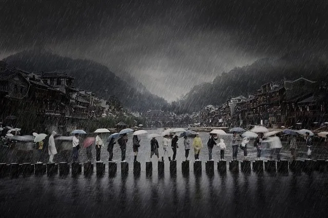 “«Rain in Ancient Town» was shot in southern China- phoenix Town, which shows the scene of people traveling in the rain during the rainy season”. (Photo and caption by Chen Li/2014 Sony World Photography Awards)