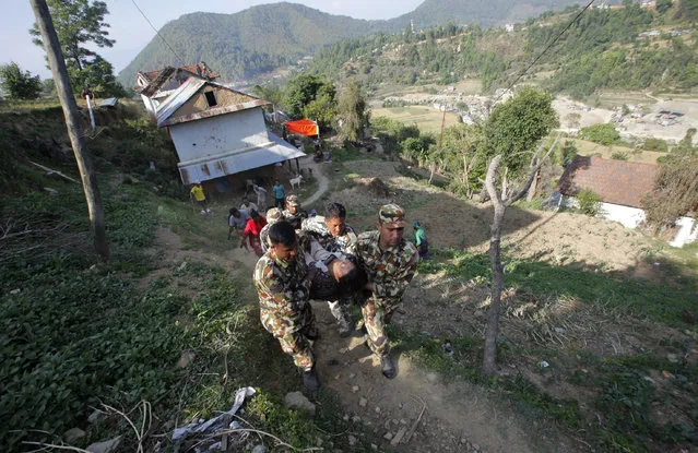 Nepalese army soldiers carry Samjhana Khadka, 28, who was injured when her house that was damaged in the April 25 earthquake collapsed in Tuesday's earthquake, at Lele in Lalitpur, Nepal, Thursday, May 14, 2015. (Photo by Bikram Rai/AP Photo)