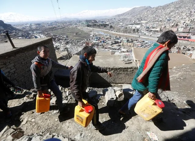 Afghan boys carry water they as they climb a hill in Kabul, Afghanistan February 20, 2017. (Photo by Omar Sobhani/Reuters)