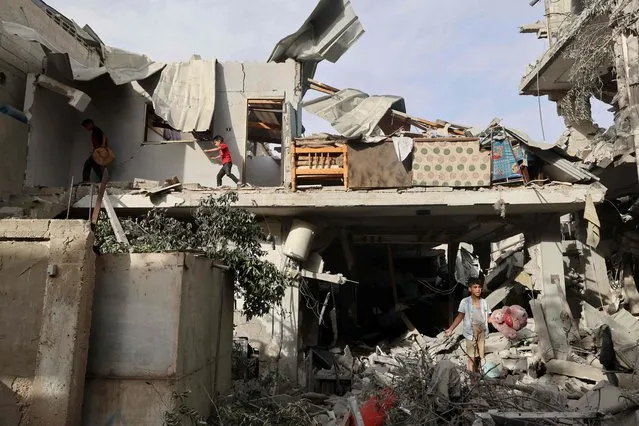 Palestinian youths search the rubble of a building hit in overnight Israeli bombardment in Rafah in the southern Gaza Strip, on April 25, 2024 amid the ongoing conflict between Israel and the Palestinian militant group Hamas. (Photo by Mohammed Abed/AFP Photo)