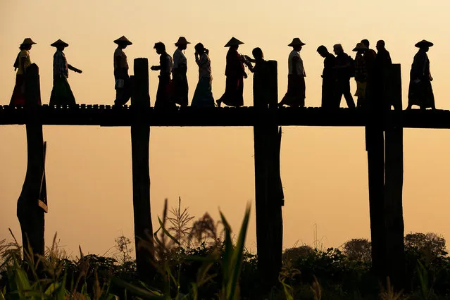 “U Bien Bridge Crossing”. Locals, Monks, Kids, Tourist walking on U Bien bridge made out of teakwood. Photo location:  Amarapura, South of Mandalay, Myanmar. (Photo and caption by April Badilles/National Geographic Photo Contest)