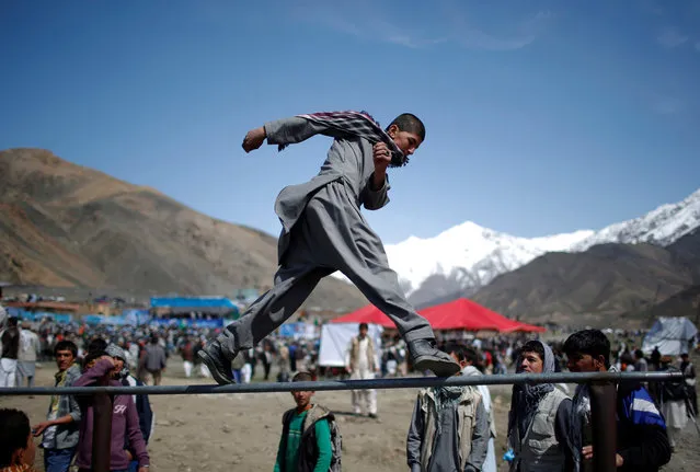 A man walks on a pole before the start of a campaign by Afghan presidential candidate Abdullah Abdullah in Panjshir province March 31, 2014. (Photo by Ahmad Masood/Reuters)