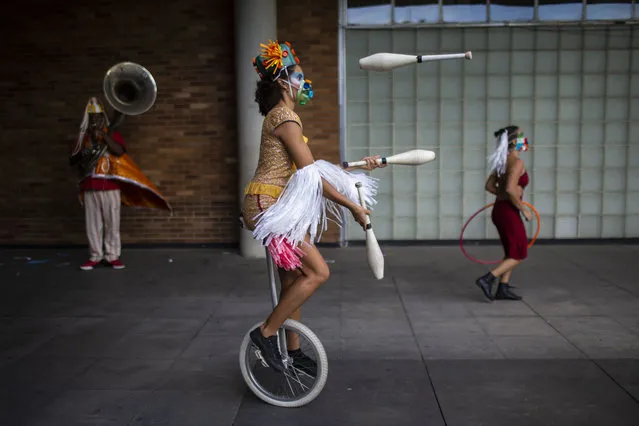 Performance artist Denise Lomeli juggles on a unicycle during a video recording of “The Giants Dreamers” outside the Museum of Modern Art (MAM) during the COVID-19 pandemic in Rio de Janeiro, Brazil, Tuesday, March 9, 2021. Brazil’s Congress approved in 2020 a financial lifeline for artists, as well as to maintain cultural venues and small troupes that had to cease activities. (Photo by Bruna Prado/AP Photo)