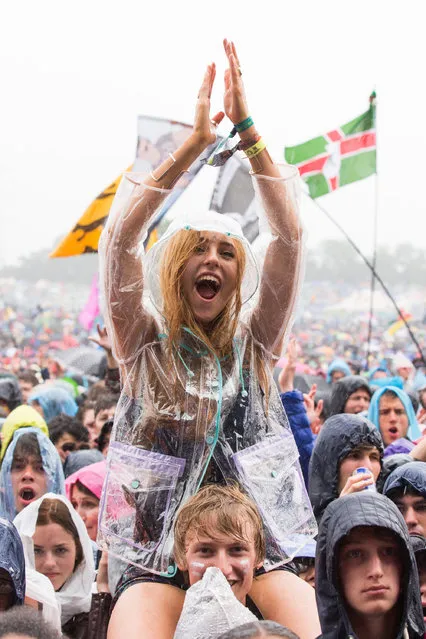 Festival goers enjoy the music of Alabama Shakes  during a shower at Glastonbury Music Festival on Friday, June 26, 2015 at Worthy Farm, Glastonbury, England. (Photo by Jim Ross/Invision/AP Photo)