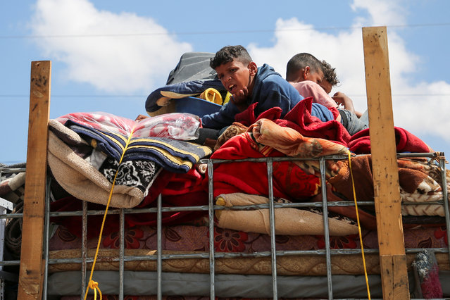 Palestinians staying atop their belongings prepare to evacuate after Israeli forces launched a ground and air operation in the eastern part of Rafah, in Rafah, in the southern Gaza Strip on May 7, 2024. (Photo by Hatem Khaled/Reuters)