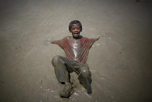 A boy plays on the mud during the Asar Pandhra festival in Pokhara valley, west of Nepal's capital Kathmandu, June 30, 2015. (Photo by Navesh Chitrakar/Reuters)