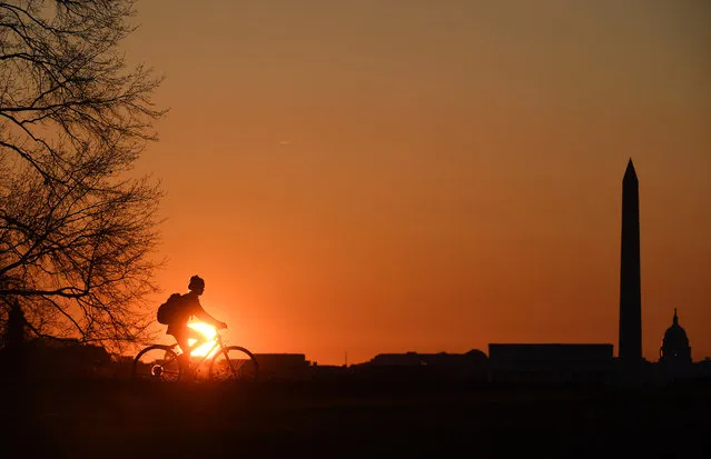 A bicyclist rides near the Netherlands Carillon as the sun rises on Wednesday April 05, 2017 in Washington, DC. (Photo by Matt McClain/The Washington Post)