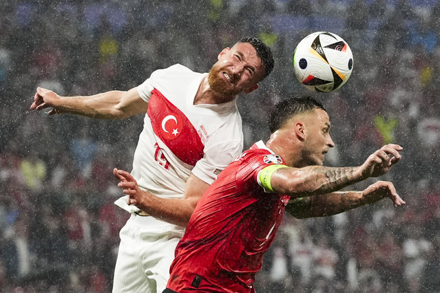 Turkey's Salih Ozcan, left, and Austria's Marko Arnautovic head the ball during a round of sixteen match between Austria and Turkey at the Euro 2024 soccer tournament in Leipzig, Germany, Tuesday, July 2, 2024. (Photo by Martin Meissner/AP Photo)