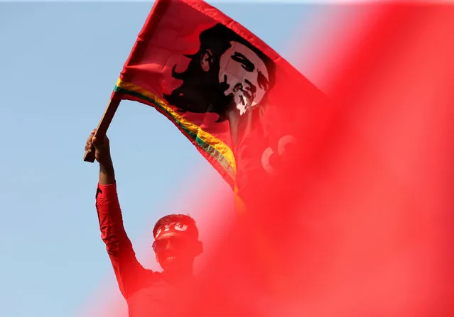 A man waves a flag with an image of Che Guevara at a march during the May Day or Labour Day rally organised by People's Liberation Front opposition party in Colombo, Sri Lanka. (Photo by Dinuka Liyanawatte/Reuters)