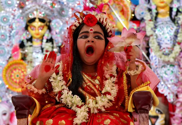 Nidhi Bhattacharjee, 5, dressed as a Kumari, yawns as she is worshipped by Hindu priests (unseen) as part of a ritual during the Durga Puja festival celebrations in Agartala, India, October 6, 2019. (Photo by Jayanta Dey/Reuters)