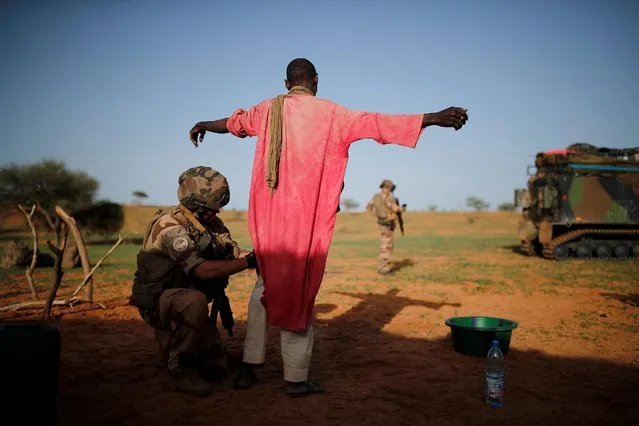 A French soldier of the 2nd Foreign Engineer Regiment searches a man during an area control operation in the Gourma region during Operation Barkhane in Ndaki, Mali, July 27, 2019. (Photo by Benoit Tessier/Reuters)