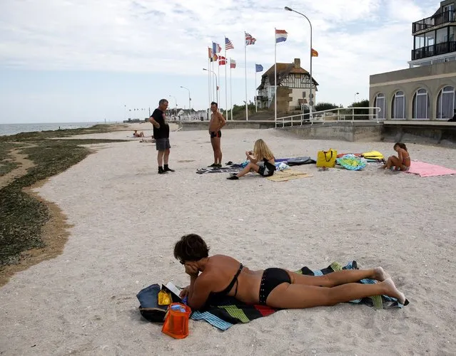 A tourist sunbathes on a former Juno Beach landing area where Canadian troops came ashore on D-Day at Bernieres Sur Mer, France, August 23, 2013. REUTERS/Chris Helgren