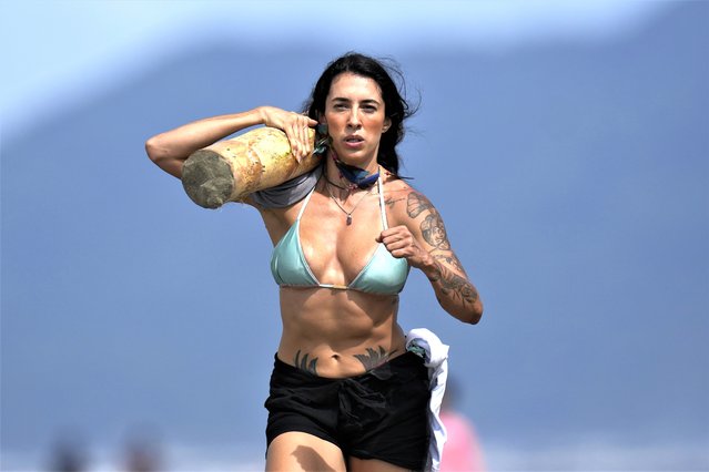 An athletes competes in a log carrying relay race event at Peruibe beach during the Indigenous Games, near the Tapirema community of Peruibe, Brazil, Sunday, April 23, 2023. Hundreds of Indigenous athletes gather this weekend in the south of Sao Paulo state to hold their version of the Olympic Games. They will compete for medals in archery, tug of war, athletics, Indigenous wrestling and other sports. (Photo by Andre Penner/AP Photo)