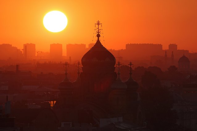 The sun rises behind the Church of the Dormition of the Mother of God in Saint Petersburg, Russia on July 17, 2024. (Photo by Anton Vaganov/Reuters)