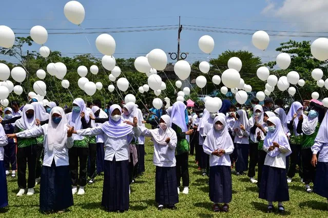 Students hold white balloons during a demonstration against violence, after recent incidents between Thai rangers and suspected separatists, in Ra-ngae district in the southern Thai province of Narathiwat on March 21, 2022. (Photo by Madaree Tohlala/AFP Photo)