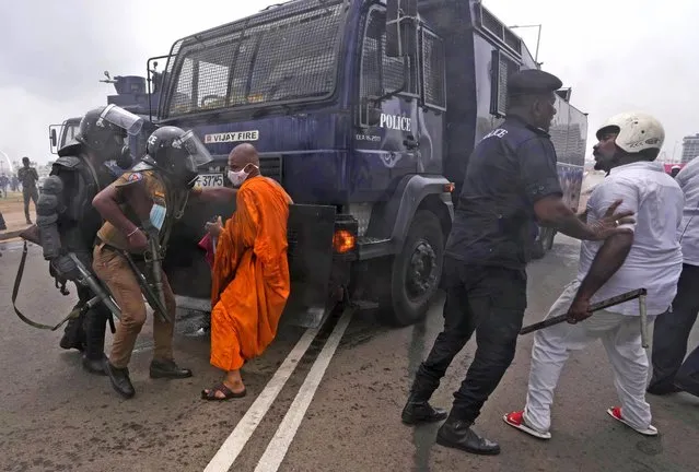 Supporters of Sri Lankan government attempt to block a police water canon truck during a clash with anti government protesters in Colombo, Sri Lanka, Monday, May 9, 2022. Government supporters on Monday attacked protesters who have been camped outside the office of Sri Lanka's prime minster, as trade unions began a “Week of Protests” demanding the government change and its president to step down over the country's worst economic crisis in memory. (Photo by Eranga Jayawardena/AP Photo)