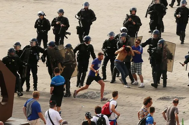 French riot police move in to detain Russian soccer fans after violence broke out between supporters ahead of the England vs Russia Euro 2016 soccer match, in Marseille, France, Saturday June 11, 2016. (Photo by Niall Carson/PA Wire via AP Photo)