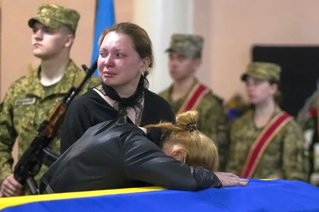 Relatives mourn during a funeral service for Army Col. Oleksander Makhachek in Zhytomyr, Ukraine, Friday, June 3, 2022. According to combat comrades Makhachek was killed fighting Russian forces when a shell landed in his position on May 30. (Photo by Natacha Pisarenko/AP Photo)