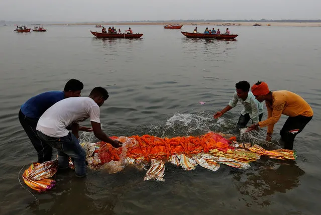 Relatives immerse a body in the river Ganges prior to cremation in Varanasi, India, April 6, 2017. (Photo by Danish Siddiqui/Reuters)