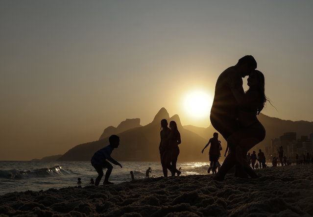 A couple embrace at Arpoador beach in Rio de Janeiro, Brazil, 25 September 2024. Rio de Janeiro recorded temperatures that reached 38°C. (Photo by Antonio Lacerda/EPA)