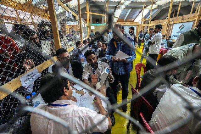 A polling official displays a sealed electronic voting machine to polling agents as they count the votes in the recent election for a local government in Indian-controlled Kashmir on the outskirts of Srinagar, Tuesday, October 8, 2024. (Photo by Mukhtar Khan/AP Photo)