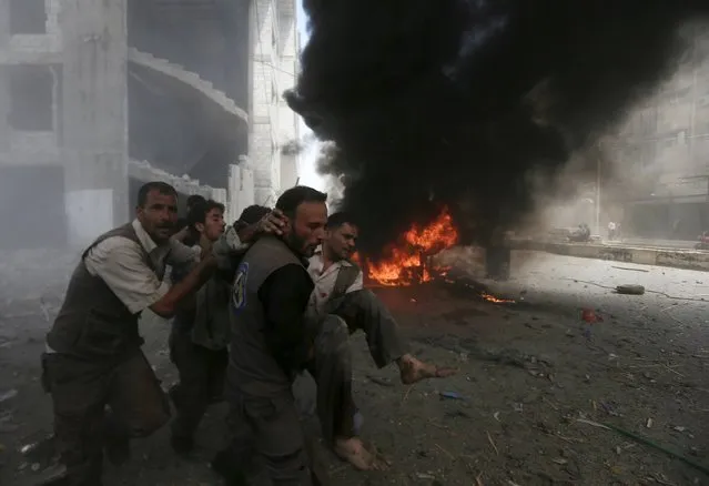 Men transport a casualty after what activists said were air strikes by forces loyal to Syria's President Bashar al-Assad on a market place in the Douma neighborhood of Damascus, Syria August 16, 2015. A Syrian government air strike northeast of Damascus killed about 80 people on Saturday, rescue workers and the Syrian Observatory for Human Rights said. (Photo by Bassam Khabieh/Reuters)