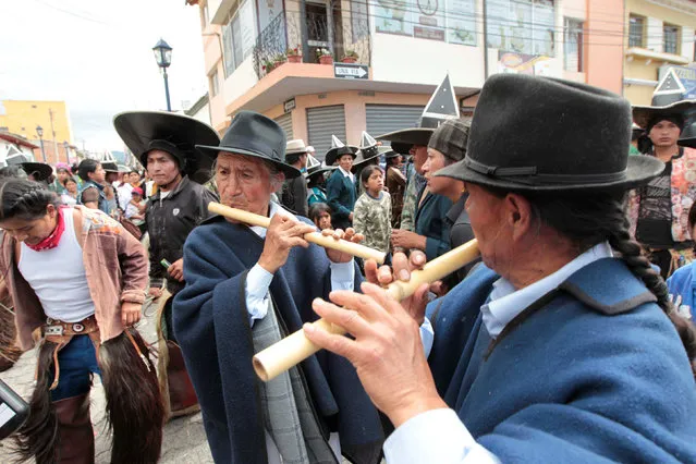 Ecuadorian indians dance as they commemorate San Juan festival, also known as Inti Raymi, around the community of Cotacachi June 29, 2016. (Photo by Guillermo Granja/Reuters)