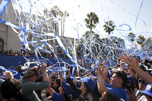 Fans cheer as buses carrying players are driven past during the Los Angeles Dodgers baseball World Series championship parade Friday, November 1, 2024, in Los Angeles. (Photo by Jae C. Hong/AP Photo)