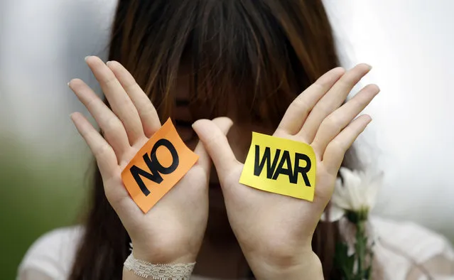 A South Korean student displays a message during a rally against the Israeli military operations in Gaza and the West Bank and wishes for peace near the Israeli Embassy in Seoul, South Korea, Wednesday, July 30, 2014. (Photo by Lee Jin-man/AP Photo)