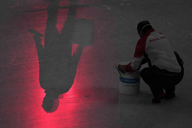 Workers repair the ice before the men's free skate program during the figure skating event at the 2022 Winter Olympics, Thursday, February 10, 2022, in Beijing. (Photo by Jae C. Hong/AP Photo)