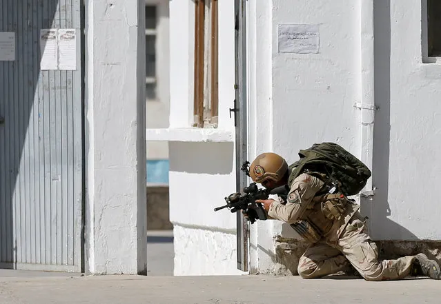 A member of the Afghan security force aims a rifle at the site of a suicide attack followed by a clash between Afghan forces and insurgents after an attack on a Shi'ite Muslim mosque in Kabul, Afghanistan on Friday, August 25, 2017. (Photo by Mohammad Ismail/Reuters)