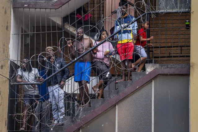 In this March 27, 2020, photo, residents of the densely populated Hillbrow neighborhood of downtown Johannesburg, confined in an attempt to prevent the spread coronavirus, stand on a staircase. South Africa went into a nationwide lockdown for 21 days in an effort to mitigate the spread to the coronavirus. (Photo by Jerome Delay/AP Photo)