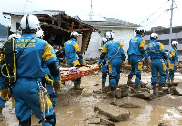 A troop of police rescue personnel head out for rescue operation after a massive landslides swept through residential area in Hiroshima, western Japan, Wednesday, August 20, 2014. (Photo by Shinpei Hamaguchi/AP Photo/Kyodo News)