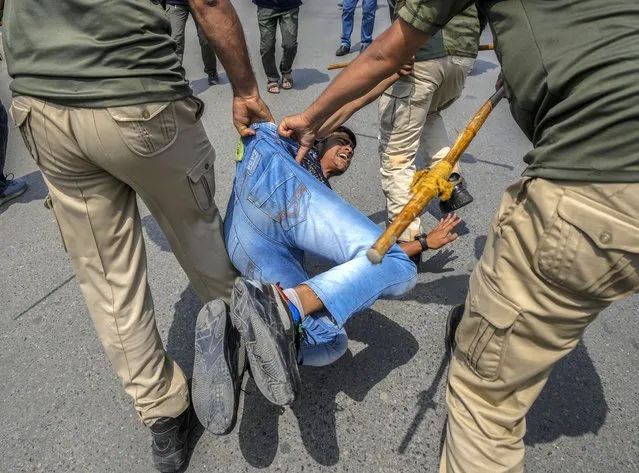 Indian policemen detain a Kashmiri Shiite Muslim for participating in a religious procession during restrictions in Srinagar, Indian controlled Kashmir, Sunday, August. 7, 2022. Authorities had imposed restrictions in parts of Srinagar, the region's main city, to prevent gatherings marking Muharram from developing into anti-India protests. (Photo by Mukhtar Khan/AP Photo)
