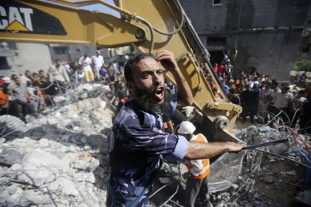 A Palestinian policeman reacts as rescue workers search for victims under the rubble of a house, which witnesses said was destroyed in an Israeli air strike that killed three senior Hamas military commanders, in Rafah in the southern Gaza Strip August 21, 2014. (Photo by Ibraheem Abu Mustafa/Reuters)
