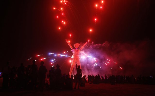 Fireworks are seen before the Man burns during the Burning Man 2014 “Caravansary” arts and music festival in the Black Rock Desert of Nevada, August 30, 2014. (Photo by Jim Urquhart/Reuters)
