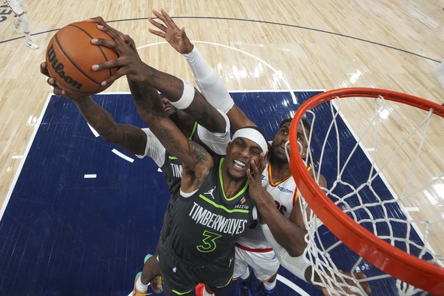 Minnesota Timberwolves center Naz Reid (11), left, forward Jaden McDaniels (3) and Golden State Warriors forward Kevon Looney (5), right, battle for a rebound during the second half of an NBA basketball game, Wednesday, January 15, 2025, in Minneapolis. (Photo by Abbie Parr/AP Photo)