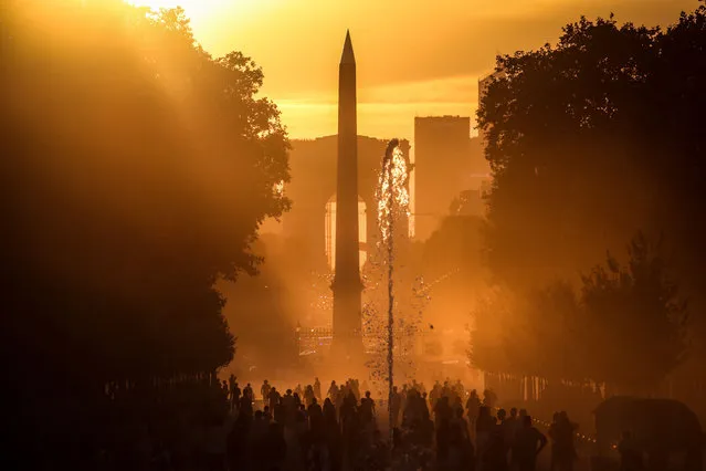 This photograph taken on August 3, 2022 shows the Luxor Obelisk and Arc de Triomphe at the sunset, in Paris. This event known as “Paris Henge” happens twice a year. (Photo by Stefano Rellandini/AFP Photo)