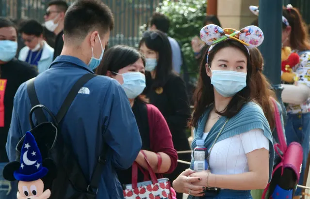 Visitors, wearing face masks, wait to enter the Disneyland theme park in Shanghai as it reopened, Monday, May 11, 2020. Visits will be limited initially and must be booked in advance, and the company said it will increase cleaning and require social distancing in lines for the various attractions. With warmer weather and new coronavirus cases and deaths falling to near-zero, China has been reopening tourist sites such as the Great Wall and the Forbidden City palace complex in Beijing.(Photo by Sam McNeil/AP Photo)