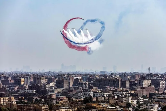 K-8E Karakorum aircraft of the Egyptian Air Force “Silver Stars” aerobatic team perform during the Pyramids Air Show 2022 above skyline of Giza, the twin city of the Egyptian capital, on August 3, 2022. (Photo by Mahmoud Khaled/AFP Photo)