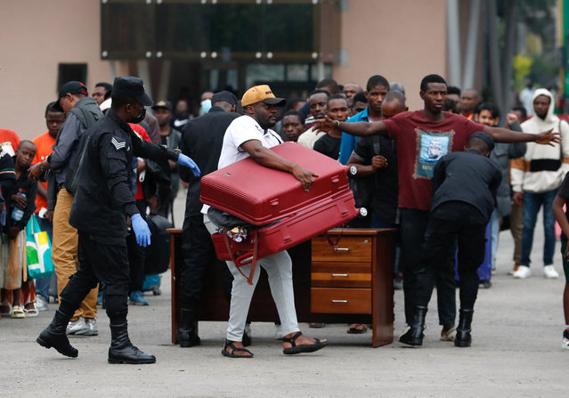 A World Bank staff member carries a suitcase, as he evacuates from eastern Democratic Republic of Congo (DRC) amid fighting between M23 rebels and the Armed Forces of the Democratic Republic of the Congo (FARDC), at the border at Gisenyi, in Rubavu district, Rwanda, on January 29, 2025. (Photo by Thomas Mukoya/Reuters)