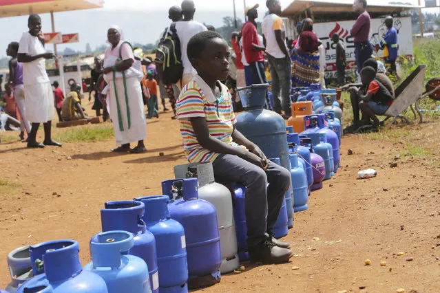 A young boy sits in a queue for cooking gas in Harare, Zimbabwe, Sunday, March, 29, 2020. Zimbabwean President Emmerson Mnangagwa announced a nationwide lockdown for 21 days, starting March 30, in an effort to stop the spread of the COVID-19 pandemic. (Photo by Tsvangirayi Mukwazhi/AP Photo)