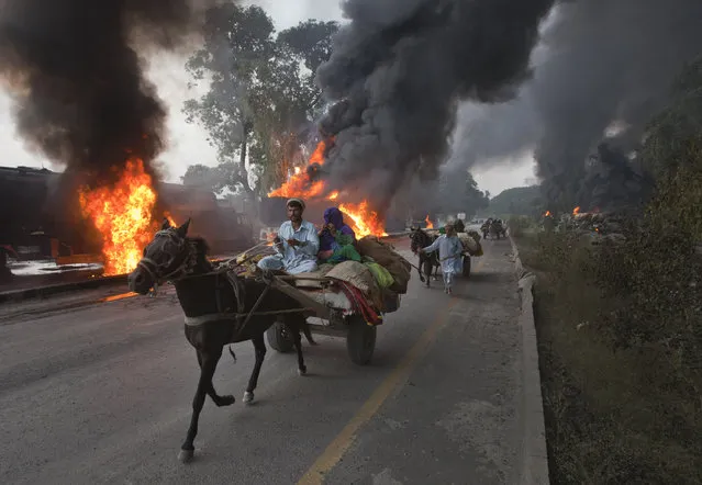 Residents on horse-led carts hurry past burning fuel tankers along the GT Road near Nowshera, located in Pakistan's Khyber-Pakhtunkhwa Province October 7, 2010. Gunmen in Pakistan set fire to up to 40 supply trucks for NATO troops in Afghanistan, police said. (Photo by Adrees Latif/Reuters)