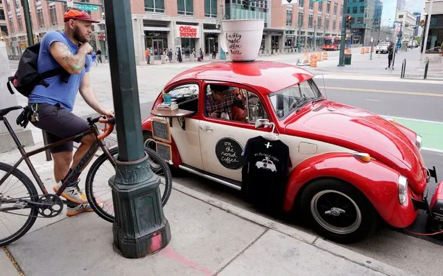 Matthew Pendleton uses brewing equipment in his 1968 VW Bug converted into a coffee cart in downtown Denver, Colorado U.S. Novemeber 1, 2017. (Photo by Rick Wilking/Reuters)