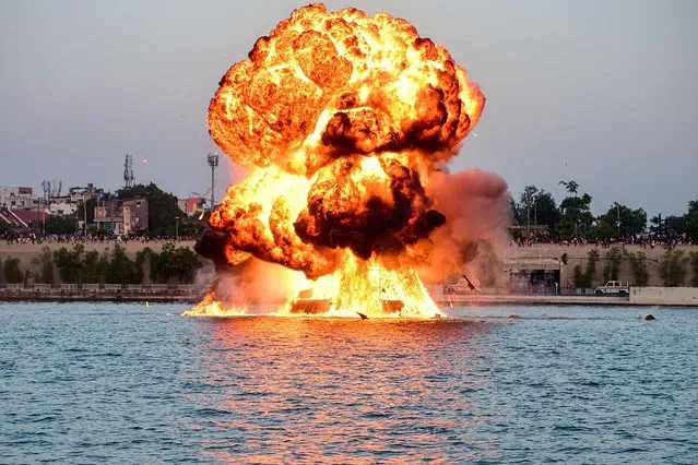 A dummy target is exploded by use of mines by Indian Navy's divers, as a part of rehearsals for the upcoming defence equipment exhibition Defence Expo 2022, at the Sabarmati Riverfront in Ahmedabad on October 16, 2022. (Photo by Sam Panthaky/AFP Photo)