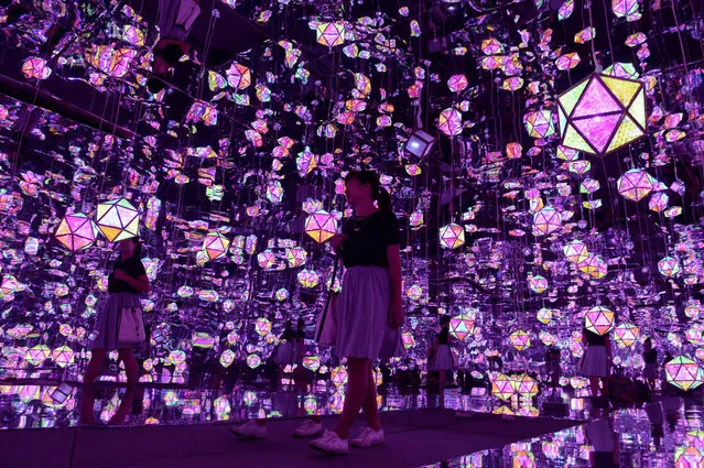 This photo taken August 18, 2016 shows a visitor walking inside a room with installation entitled “Tropical Mirage” by Onemaker Group during a preview of the Singapore Night Festival. Singapore's arts and heritage district will be transformed over two weekends in August during the Night Festival of its ninth edition featuring the theme of “Inventions and Innovation” by Singaporean and international artists. (Photo by Roslan Rahman/AFP Photo)