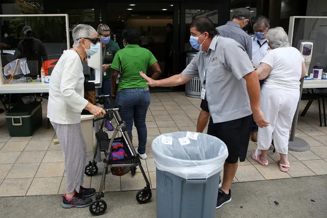 People wait for health assessment check-in before entering Jackson Memorial Hospital, as Miami-Dade County eases some of the lockdown measures put in place during the coronavirus disease (COVID-19) outbreak, in Miami, Florida, U.S., June 18, 2020. (Photo by Marco Bello/Reuters)